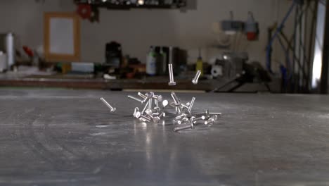 m10 bolts falling in super slow motion on a metal table