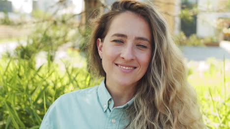 portrait of beautiful caucasian woman smiling at camera in park