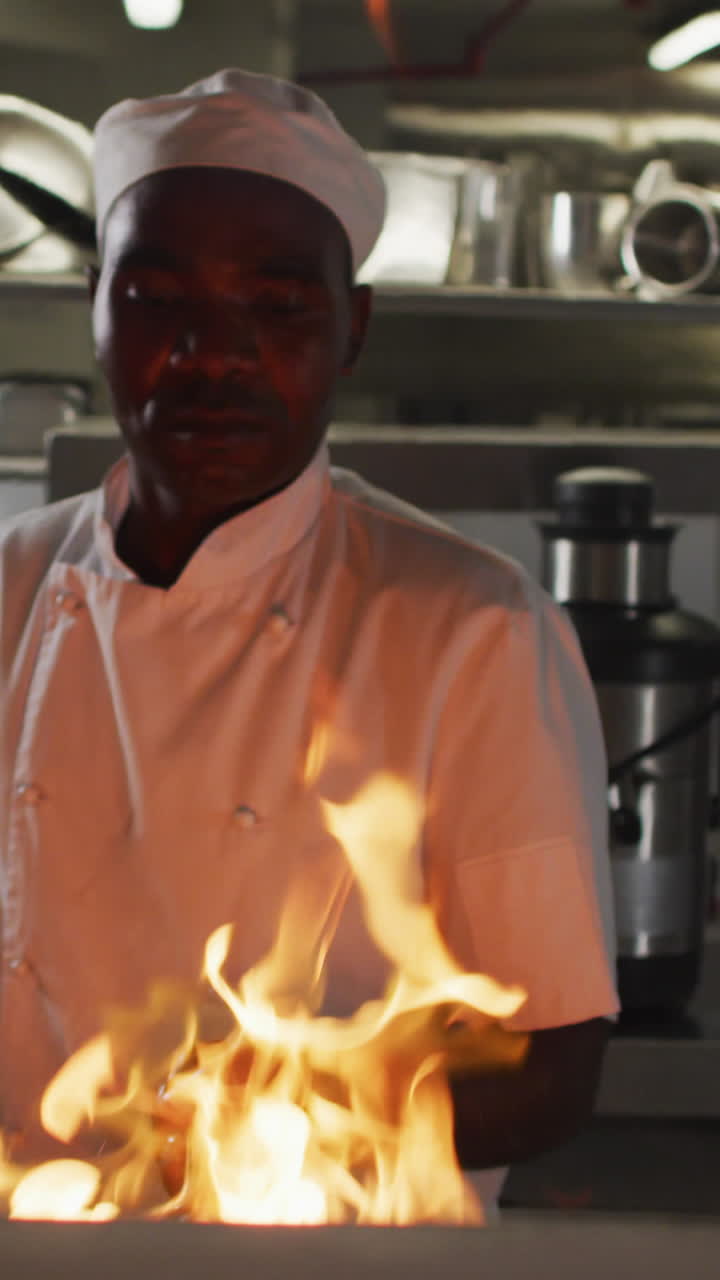 chef afroamericano fritando en una sartén en la cocina de un restaurante