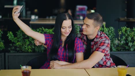 couple in love are making photo in the restaurant on the background of drinks. selfie