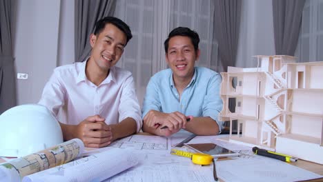 two asian architects smiling and looking at camera