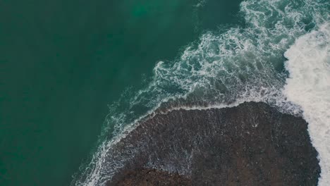 waves crashing over the beach during sunset