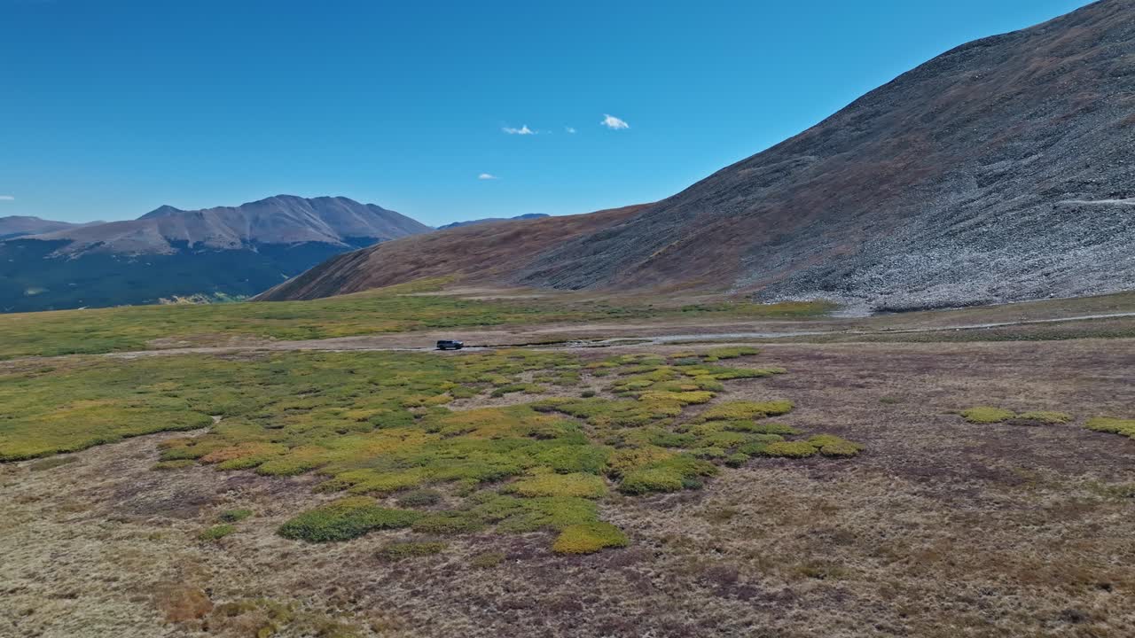 Grand scenic landscape of the high alpine meadows of Peak 10 trail Breckenridge Colorado as car drives along groomed road