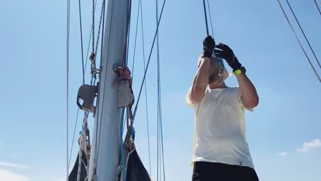 sailor working on a sailboat mast