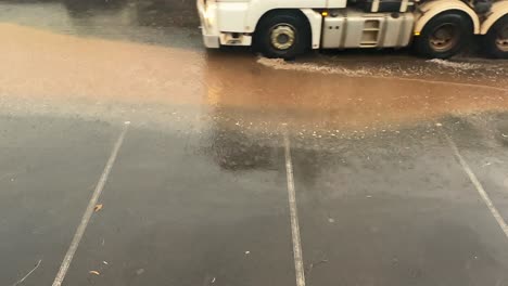 truck drive over a dirty puddle of water in the rain, static shot