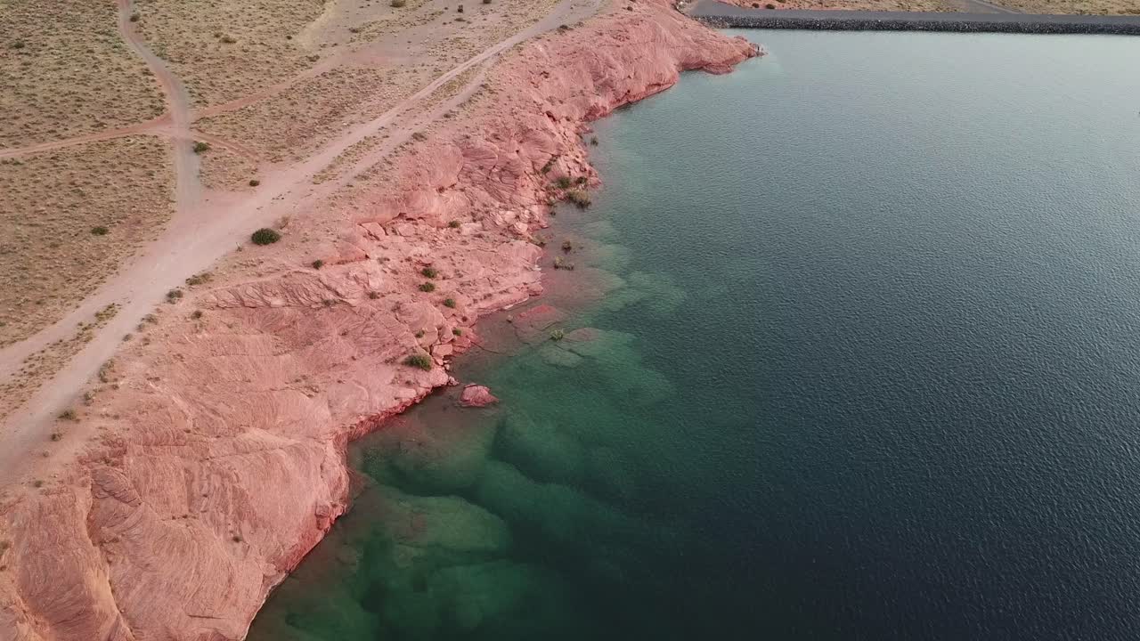 Red Rock Coast and Dusty Road by Water Reservoir. Aerial View of Sand Hollow State Park, Utah USA