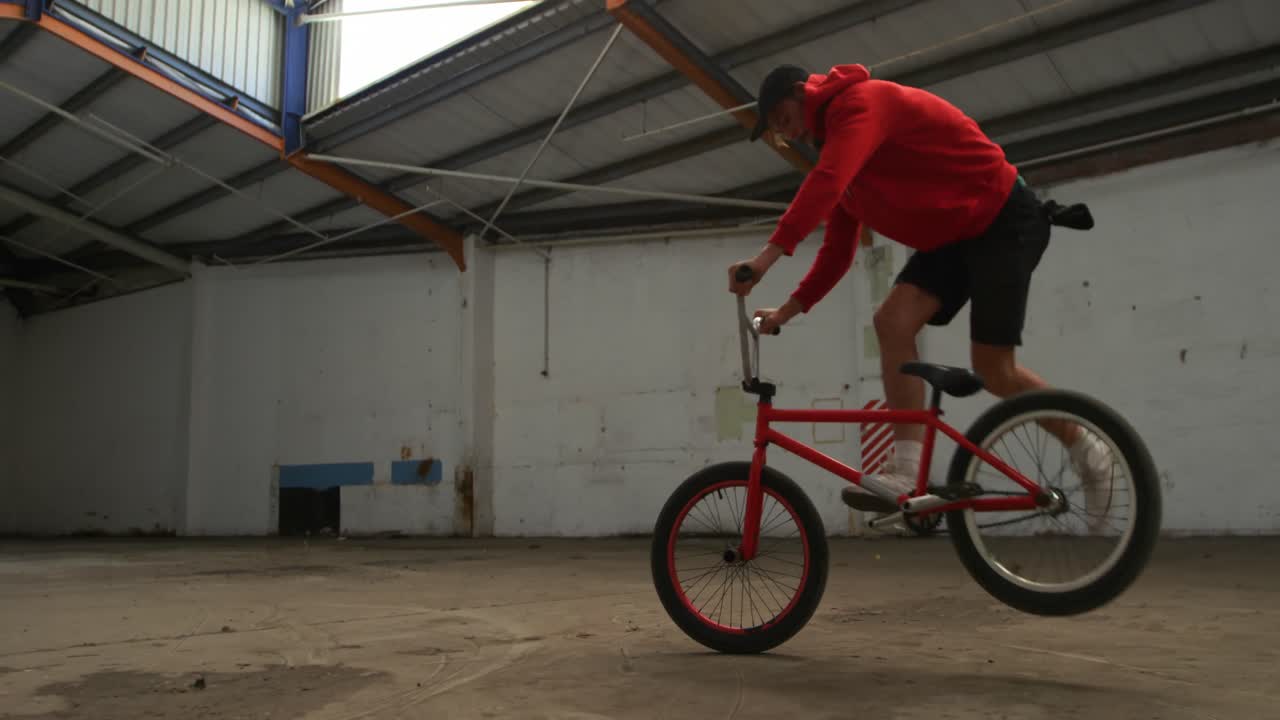 jinete de bmx en un almacén vacío