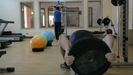 dos hombres entrenando usando equipos deportivos en el gimnasio