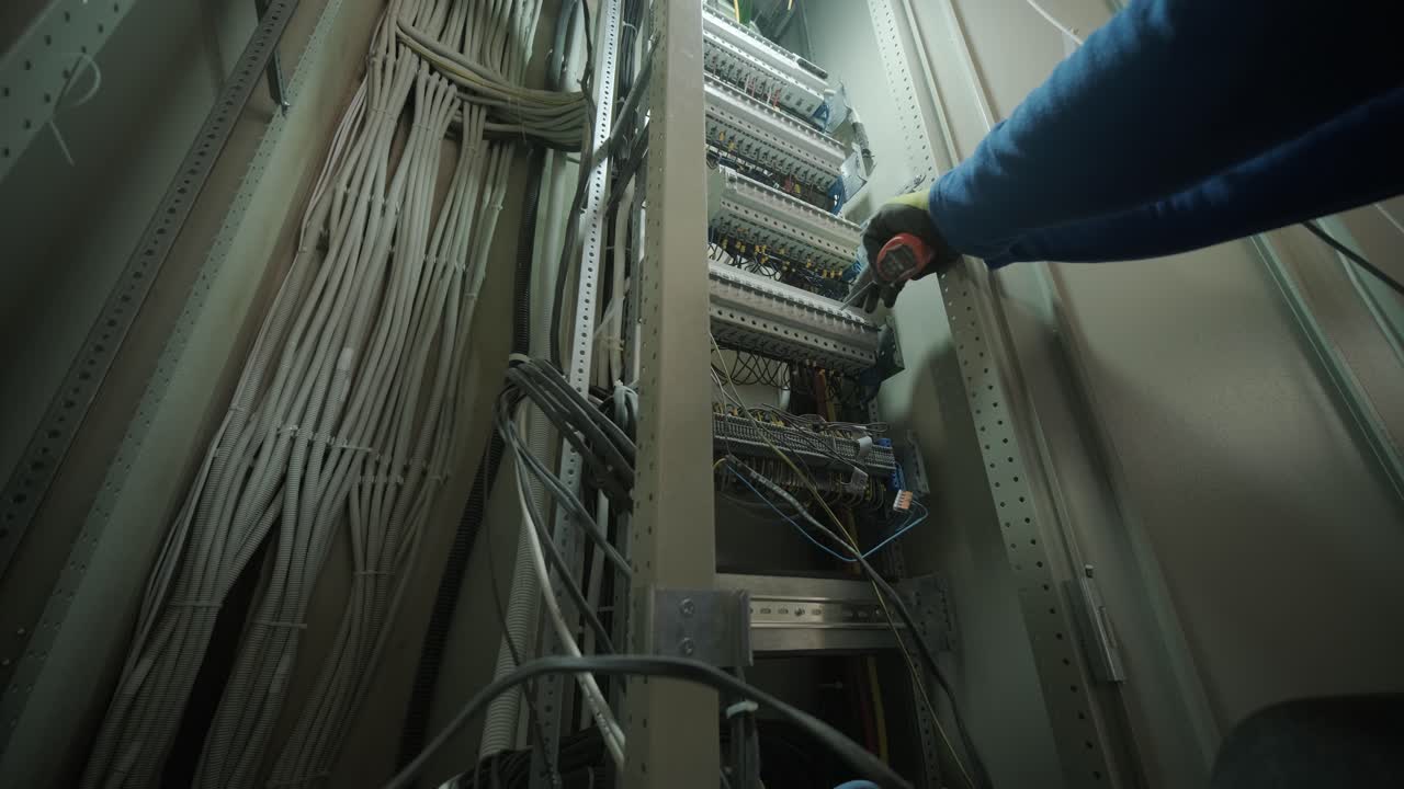 electricista trabajando en interruptores dentro del panel de control