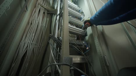 electricista trabajando en interruptores dentro del panel de control