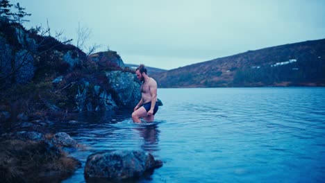 man swimming in fjord in norway - wide shot