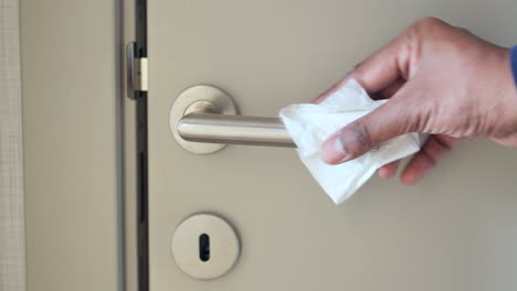 cleaning a door handle with a tissue