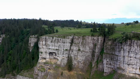 rotating drone shot of the cliff walls at creux du van in switzerland, located at the border of the cantons of neuenburg and vaud