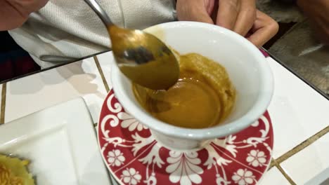 persona agitando el café en una taza blanca