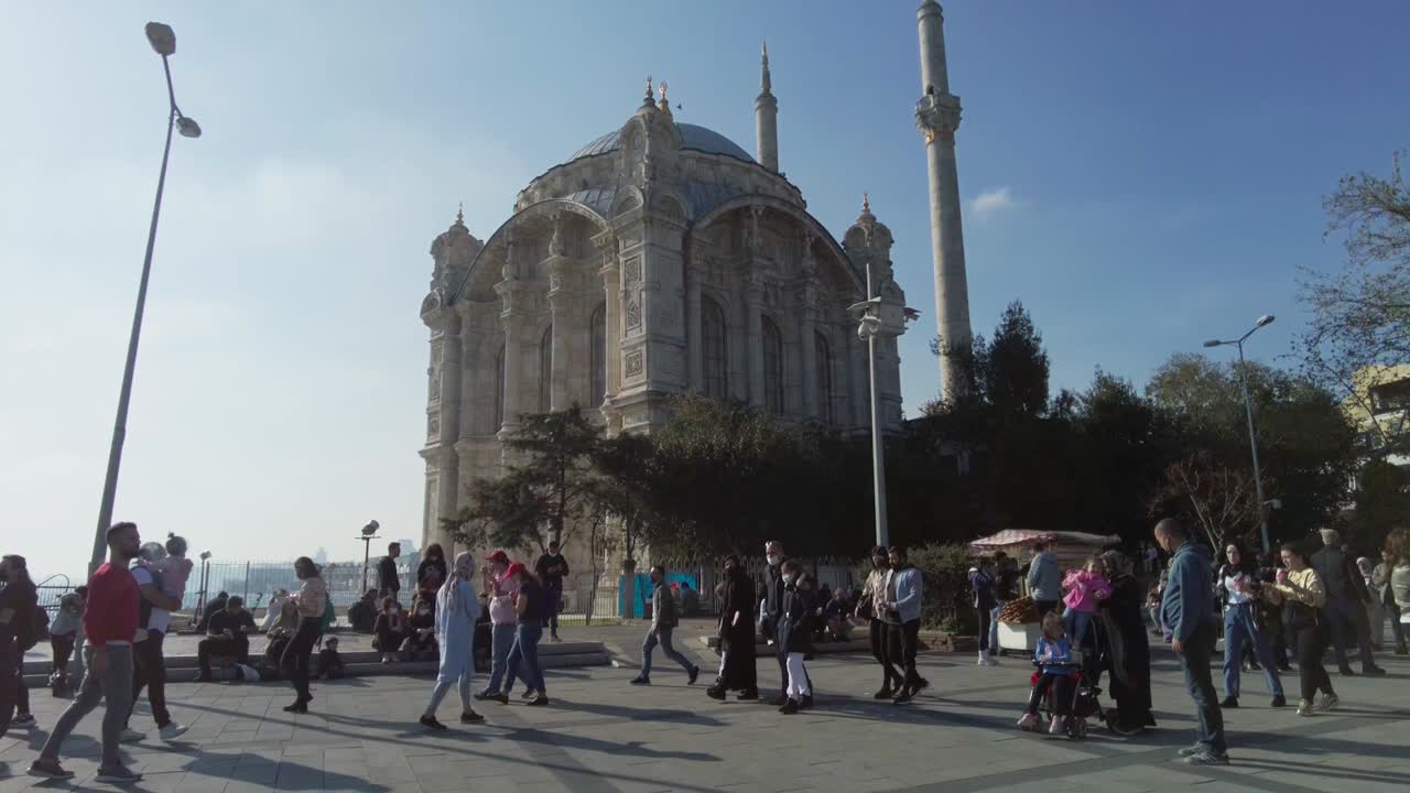 mezquita ortakoy, la gente está caminando, sentada en la plaza. pavo