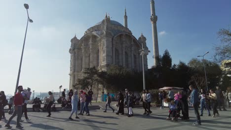 ortakoy mosque, people are walking, sitting in the square. turkey