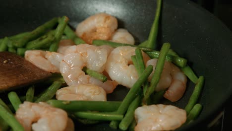 primer plano de camarones rey y frijoles finos cocinando en sartén caliente