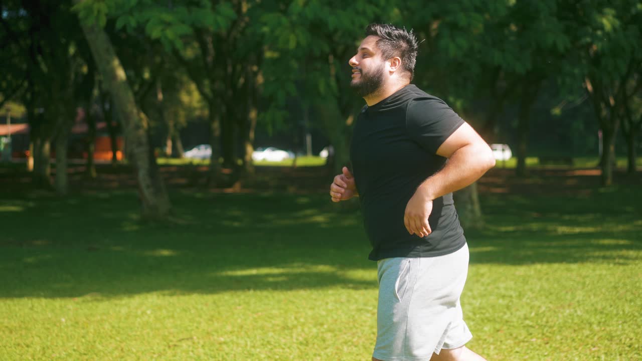 화창한 여름날 공원에서 조깅하는 행복한 남자를 따라