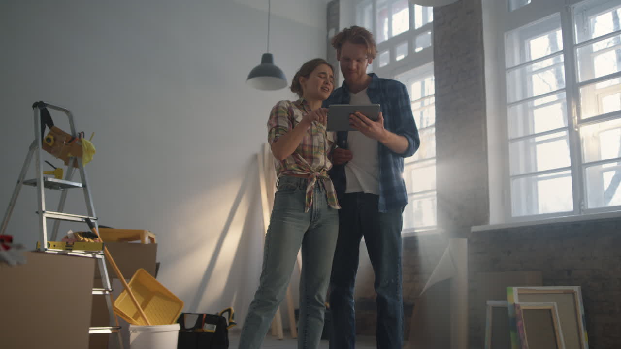 proyecto de diseño de familia joven en la tableta. mujer mostrando diseño en el gadget.