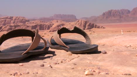 a pair of well worn sandals sits in the saudi desert of wadi rum jordan