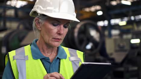 senior female engineer inspecting a factory with a digital tablet