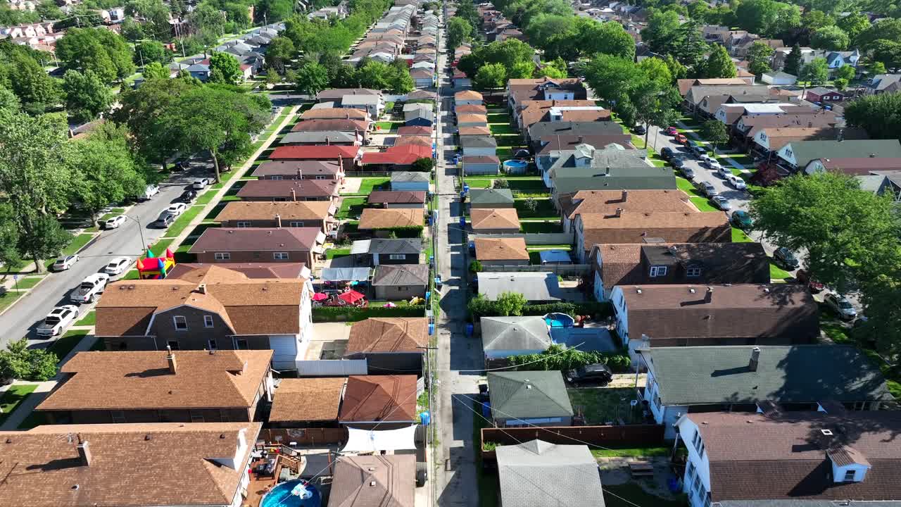 suburbio de chicago con filas de casas de techo marrón y patios verdes en verano
