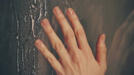 hand touching wet glass