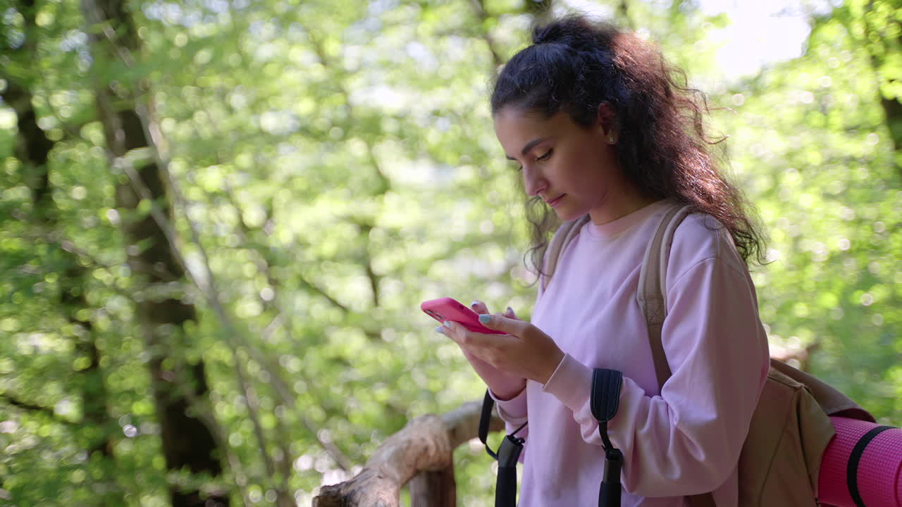 adolescente usando el teléfono en el bosque