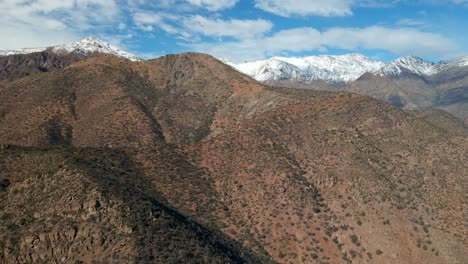 aerial view dolly in from morro las papas, san carlos de apoquindo park, snowcapped mountain in the background on a clear day, santiago, chile