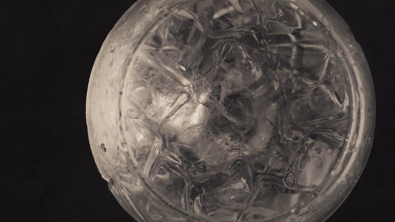 Primo piano di pinzette che mettono limone in un bicchiere d'acqua. Concetto di processo di preparazione di un cocktail.