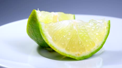 una rebanada de limón verde está girando lentamente en el estudio con los detalles.