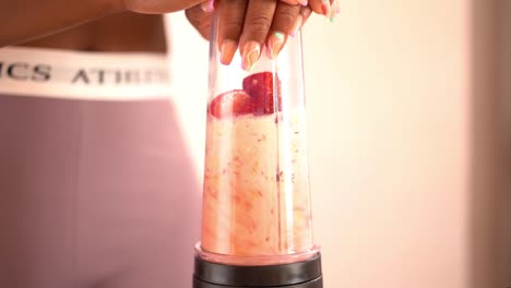 Crop-ethnic-woman-preparing-smoothie-in-blender