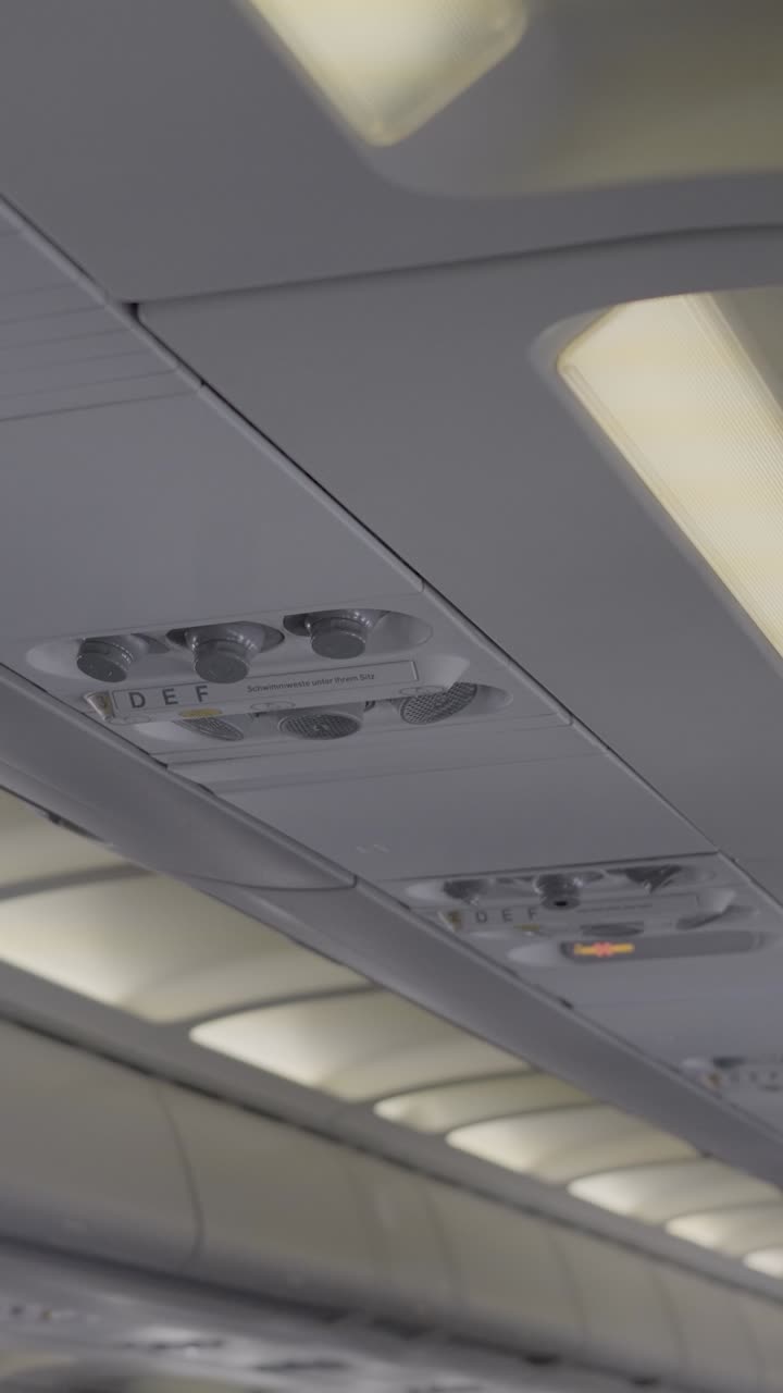 Airplane interior with overhead panel and illuminated signs