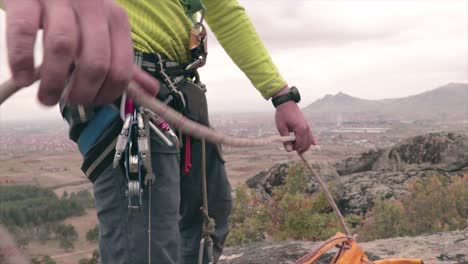 escalador con un equipo de escalada sacando una cuerda de una bolsa