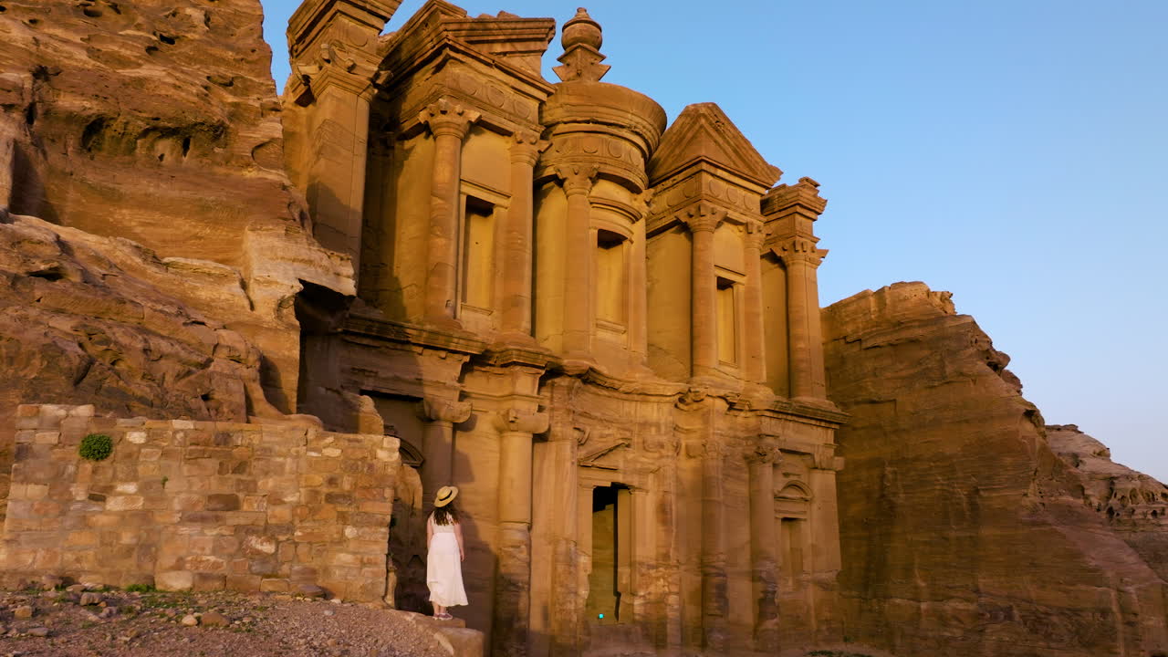 mujer admirando el icónico monasterio ad deir en la antigua ciudad de petra al atardecer