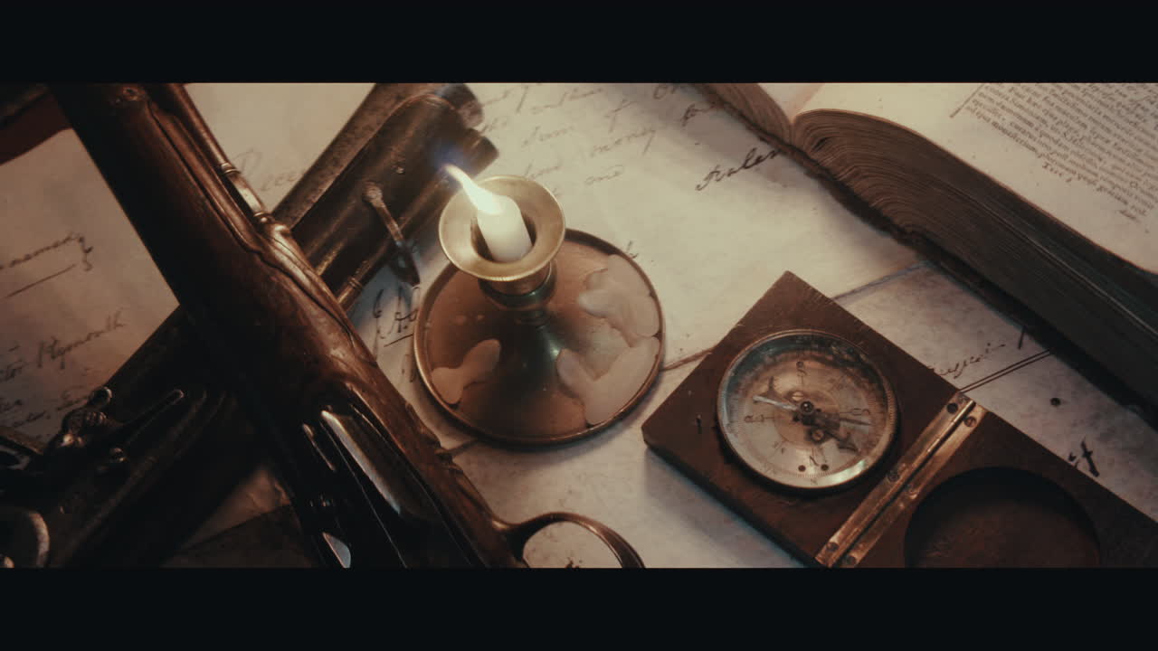 Two pistols and compass on the table filled with documents and maps inside the sailing ship cabin