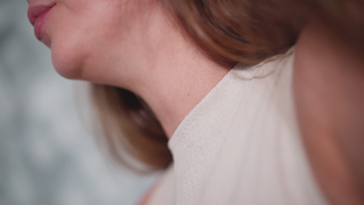 Close up side view of lady jaw moving while chewing food, wearing sleeveless textured top, soft natural lighting highlights smooth skin and hair strands, blurred background