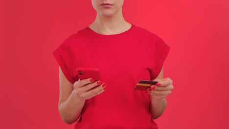 woman holding credit card and mobile phone