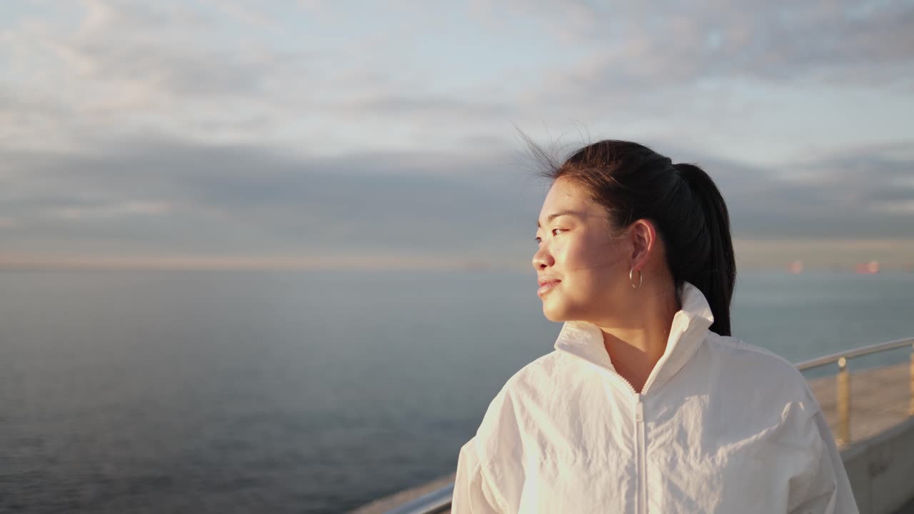海の水平線を眺める物思いにふける若いアジア人女性