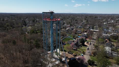 An-aerial-view-of-a-water-tower-in-the-process-of-being-dismantled-on-a-sunny-day-on-Long-Island,-New-York