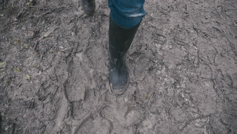 muddy boots walking along a muddy path in slow motion