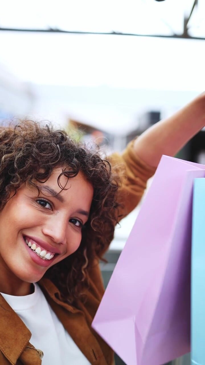 Giovane donna felice sorridente con borse della spesa colorate