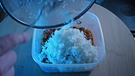 Agregando-Arroz-Blanco-Sobre-Pavo-Molido-Cocido-Con-Frijoles-En-Un-Recipiente-De-Comida