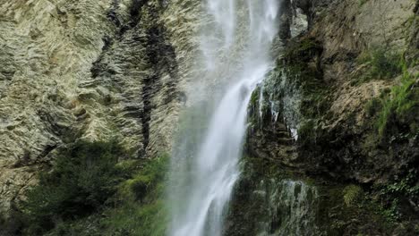 water stream from waterfall crashing onto rocks at the cliff side, handheld closeup