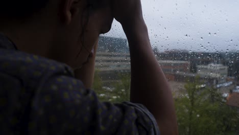 un joven europeo asiático deprimido en luto mirando hacia un día gris lluvioso
