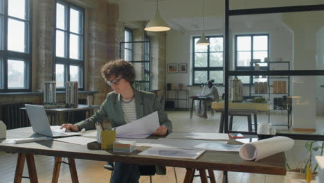 female architect reviewing blueprints in a modern design office
