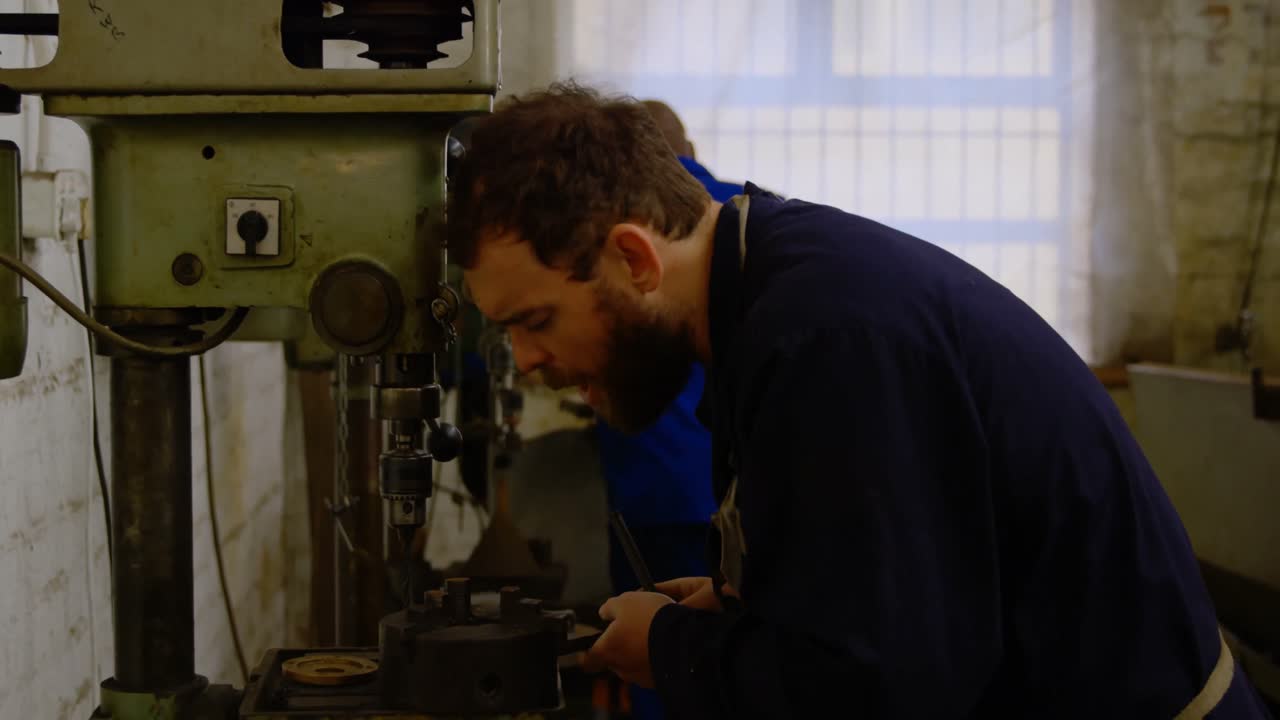 Metalsmith using drill press machine in workshop 4k
