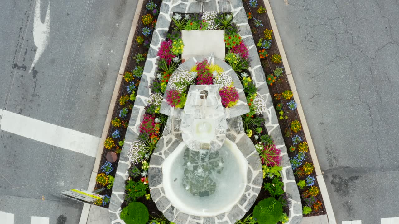Parterre ajardinado en la plaza de la ciudad con banderas estadounidenses.
