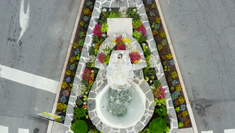 landscaped flower bed in town square with american flags