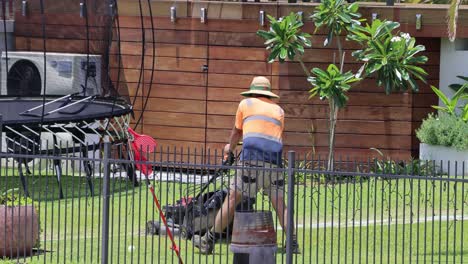 worker mowing and maintaining a lush green lawn